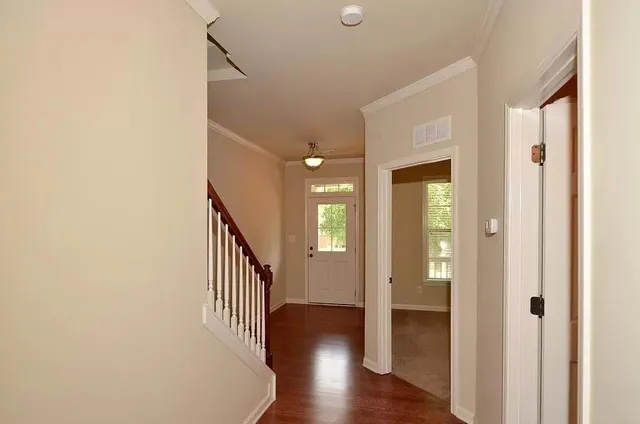 a view of a hallway with wooden floor and staircase