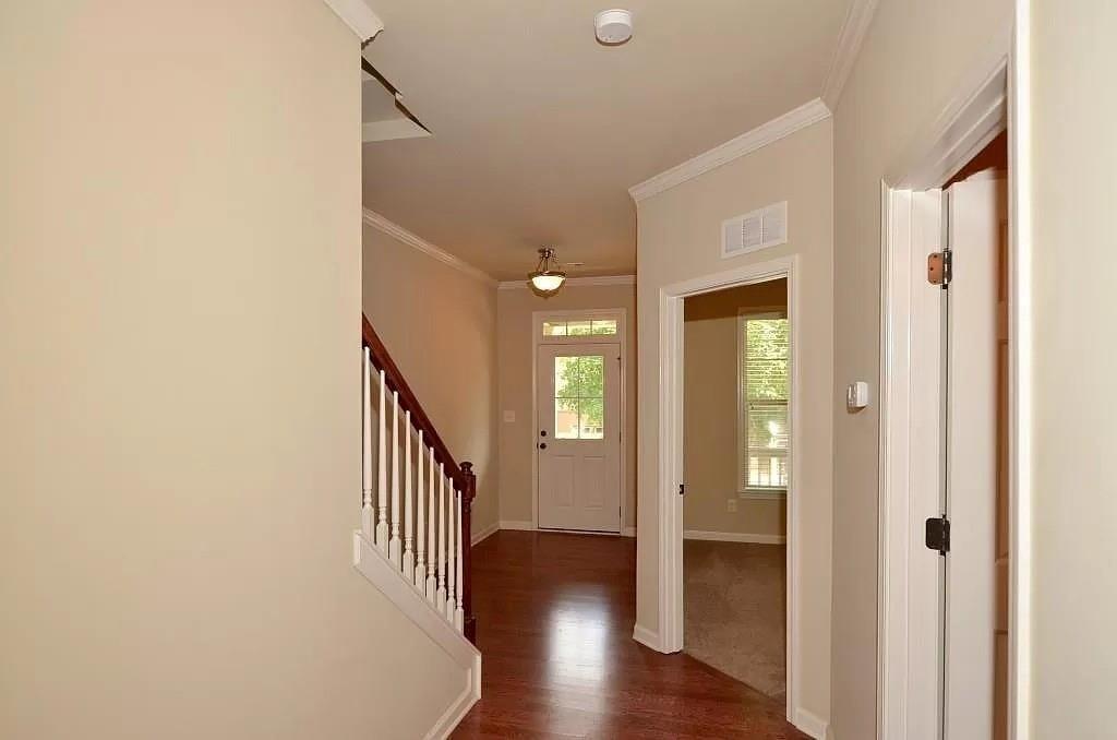 4411 Village Field Place Suwanee, GA 30024 - Photo 2 of 9 a view of a hallway with wooden floor and staircase