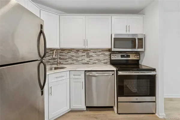 a kitchen with stainless steel appliances granite countertop a stove a microwave and a refrigerator