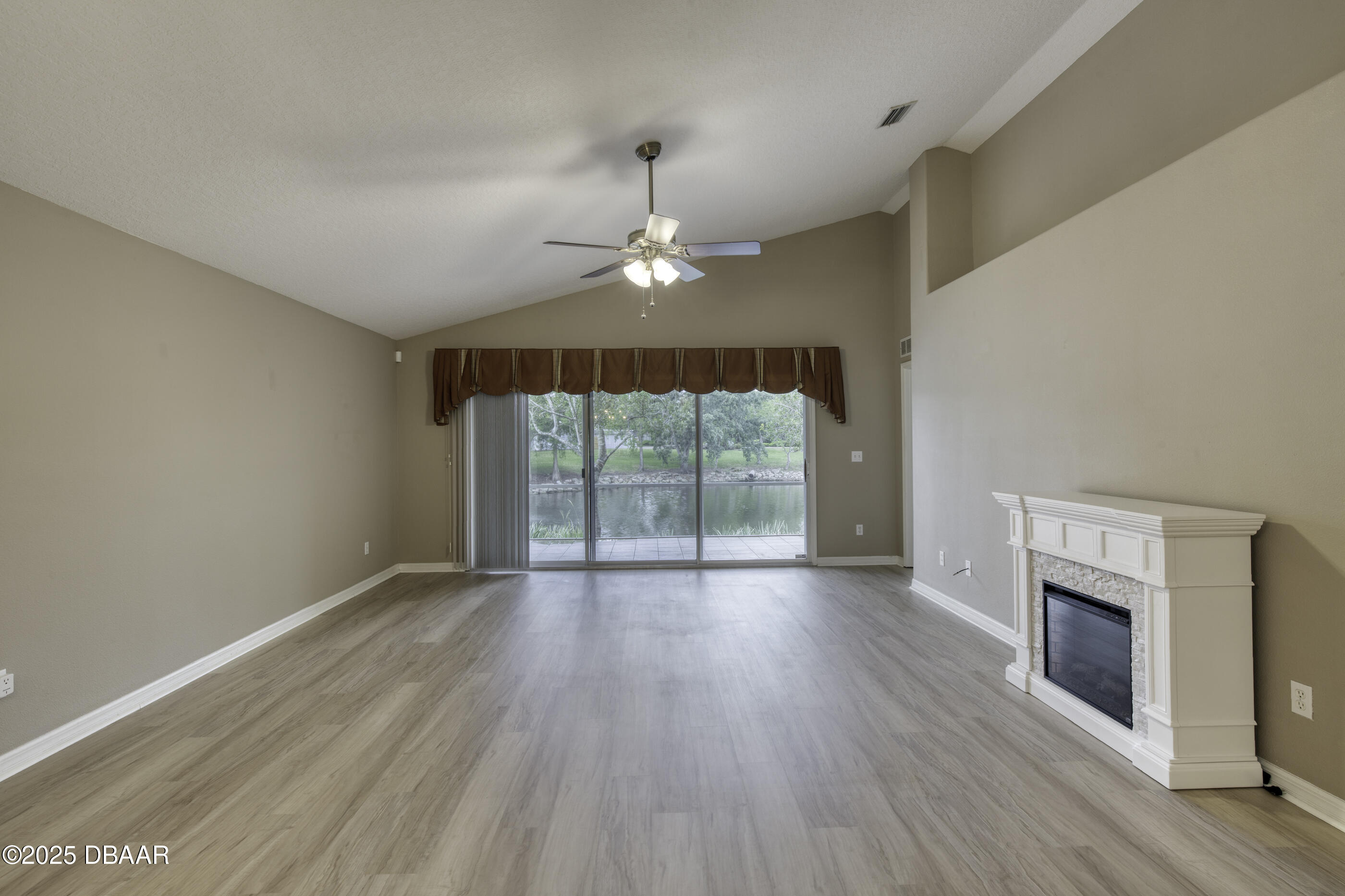 38 Lake Walden Trail Ormond Beach, FL 32174 - Photo 22 of 72 an empty room with wooden floor fireplace and windows