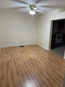 a view of an empty room with a chandelier fan