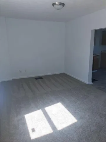an empty room with a window and a ceiling fan