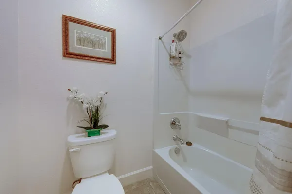 a white toilet sitting next to a bath tub
