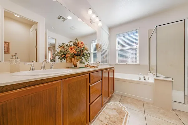a spacious bathroom with a tub sink and mirror