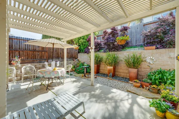 a view of a patio with table and chairs potted plants