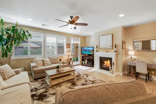 a living room with furniture a fireplace and a chandelier