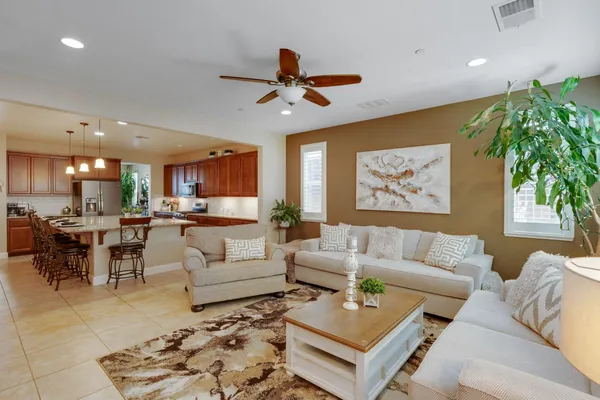 a living room with furniture kitchen view and a potted plant