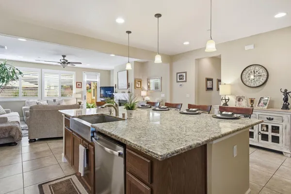 a view of center island of a kitchen with granite countertop living room