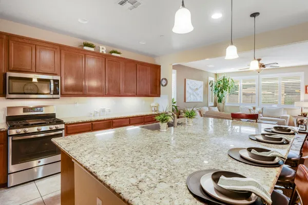 a kitchen with sink a stove and chairs