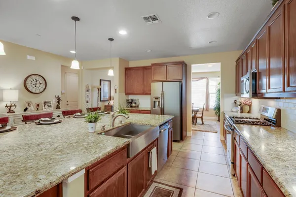 a large kitchen with granite countertop a large stove a sink and a refrigerator