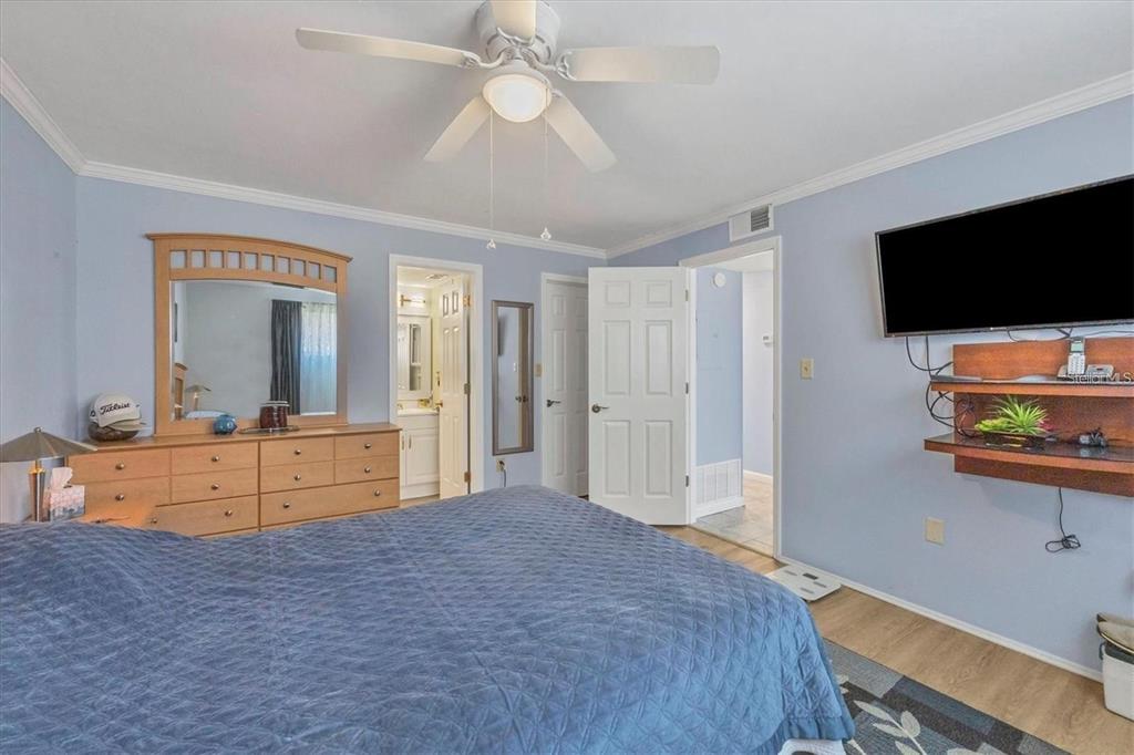 460 Base Avenue East, Unit 113 Venice, FL 34285 - Photo 11 of 25 a bedroom with furniture and a flat screen tv
