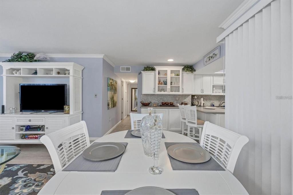 460 Base Avenue East, Unit 113 Venice, FL 34285 - Photo 13 of 25 a living room with furniture and a flat screen tv