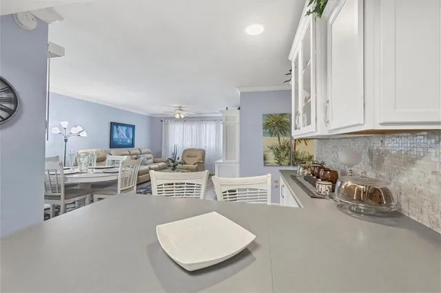 a kitchen with stainless steel appliances a stove and white cabinets