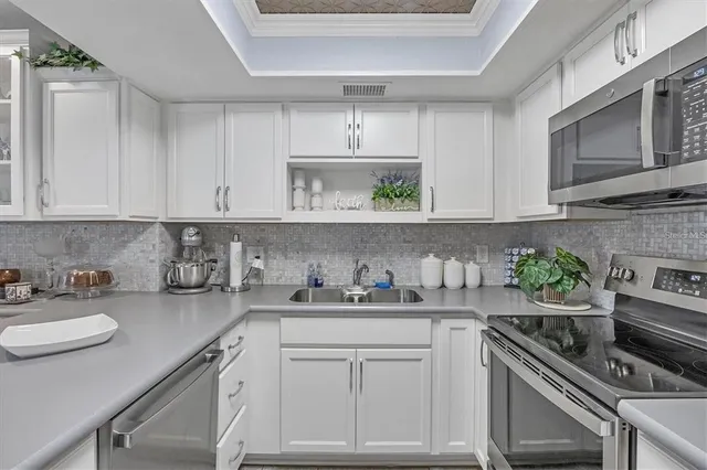 a kitchen with stainless steel appliances white cabinets and a stove top oven