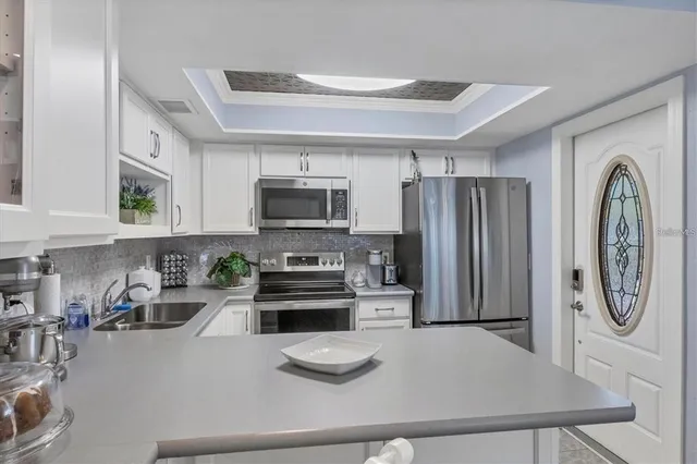 a kitchen with stainless steel appliances granite countertop a refrigerator a stove top oven a sink and dishwasher