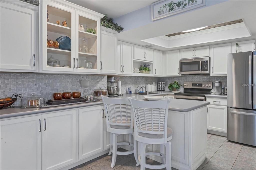 460 Base Avenue East, Unit 113 Venice, FL 34285 - Photo 20 of 25 a kitchen with stainless steel appliances granite countertop a refrigerator and cabinets
