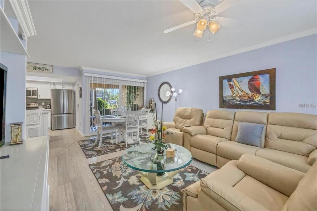 460 Base Avenue East, Unit 113 Venice, FL 34285 - Photo 23 of 25 a living room with furniture a rug and a chandelier