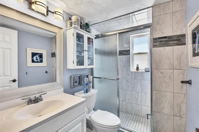 a bathroom with a sink toilet a mirror and shower