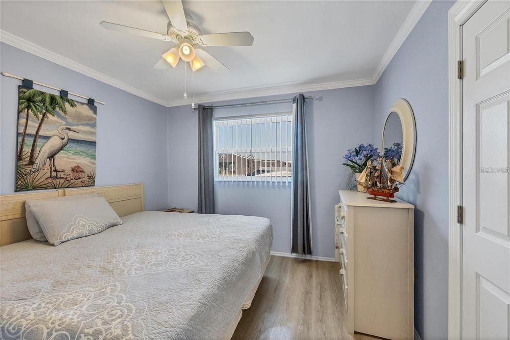 460 Base Avenue East, Unit 113 Venice, FL 34285 - Photo 7 of 25 a bedroom with a bed and a chandelier