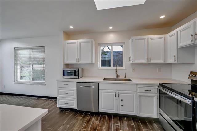 262 Beachview Avenue, Unit 5 Pacifica, CA 94044 - Photo 11 of 23 a kitchen with white cabinets stainless steel appliances and sink