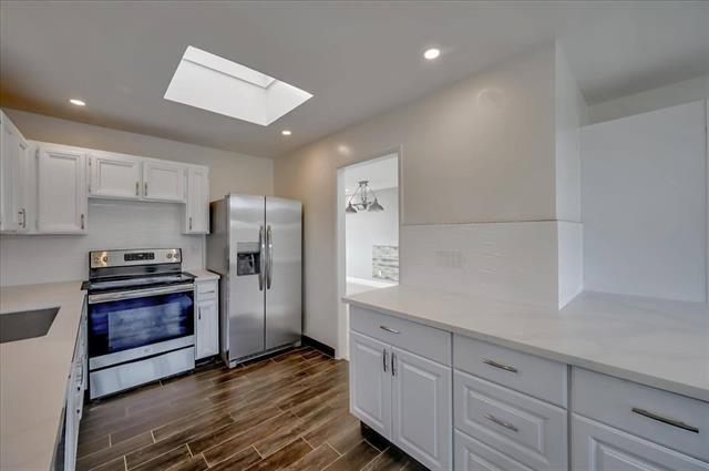 262 Beachview Avenue, Unit 5 Pacifica, CA 94044 - Photo 12 of 23 a kitchen with granite countertop a refrigerator and a stove top oven