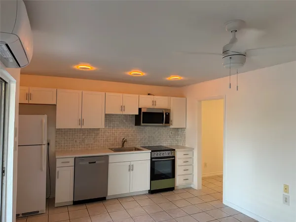 a kitchen with a refrigerator and a stove top oven