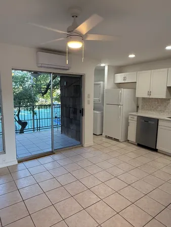 a view of a kitchen with a sink and a refrigerator