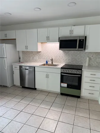 a kitchen with stainless steel appliances a stove sink and cabinets