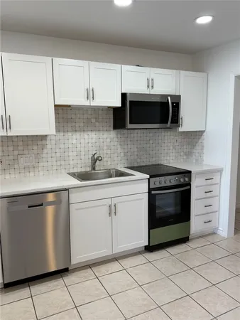 a kitchen with stainless steel appliances granite countertop a sink and a stove