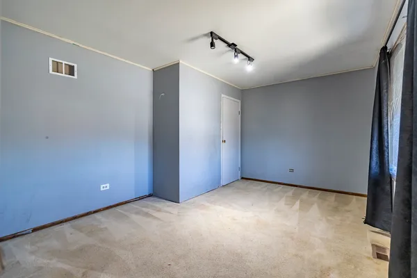 an empty room with windows and fan