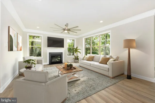 an empty room with wooden floor a fireplace and windows
