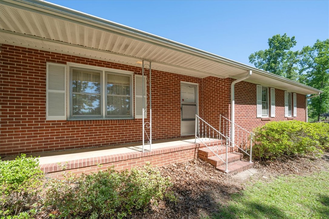 304 Shaw Road Honea Path, SC 29654 - Photo 3 of 39 This brick home presents a charming front facade with a welcoming porch and vibrant landscaping.
