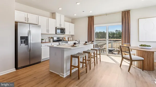 a kitchen with kitchen island a large window appliances and cabinets