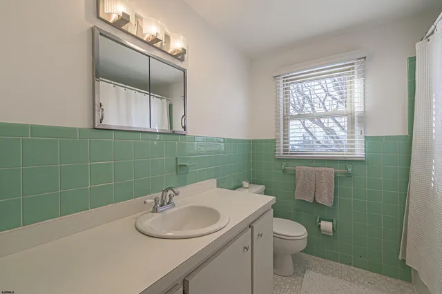 a bathroom with a sink a toilet and mirror
