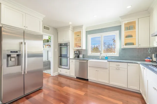 a kitchen with white cabinets and refrigerator