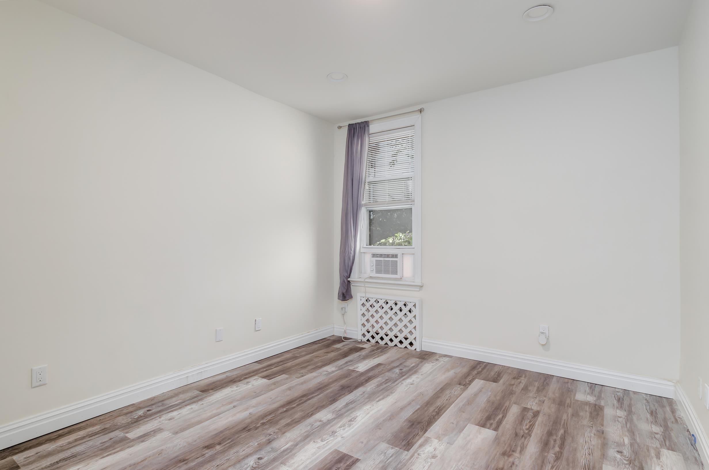 232 Pearsall Avenue, Unit 1 Jersey City, NJ 07305 - Photo 11 of 20 a view of an empty room with wooden floor and a window