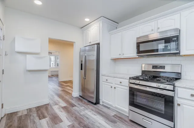 a kitchen with stainless steel appliances granite countertop a stove a refrigerator and a microwave