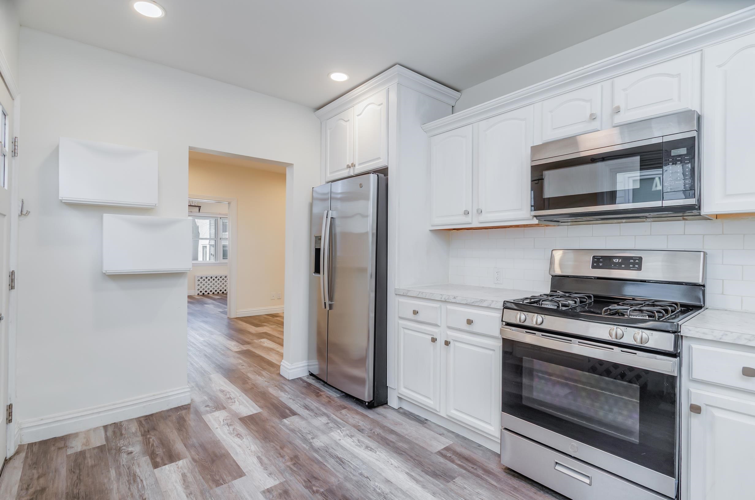232 Pearsall Avenue, Unit 1 Jersey City, NJ 07305 - Photo 6 of 20 a kitchen with stainless steel appliances granite countertop a stove a refrigerator and a microwave