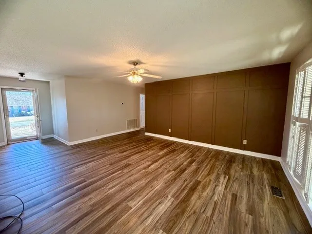 a view of an empty room with wooden floor