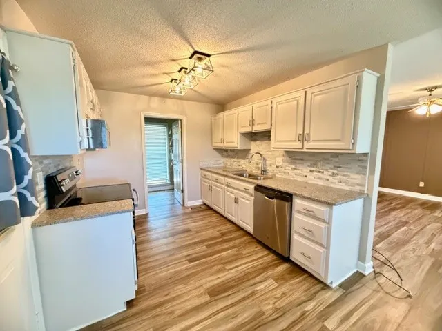 a kitchen with stainless steel appliances granite countertop a stove oven and a refrigerator