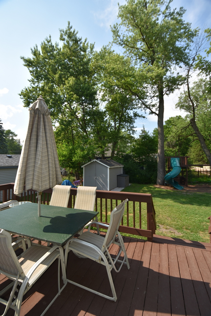 25W756 Jewell Road Wheaton, IL 60187 - Photo 22 of 25 a view of backyard with a table and chairs under an umbrella