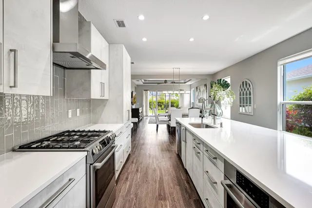 a large kitchen with stainless steel appliances granite countertop a lot of counter space a sink and a stove