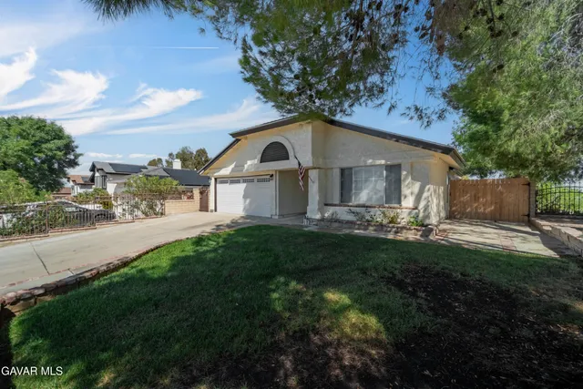 a front view of a house with a yard and green space