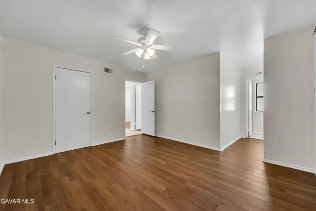 a view of an empty room with wooden floor