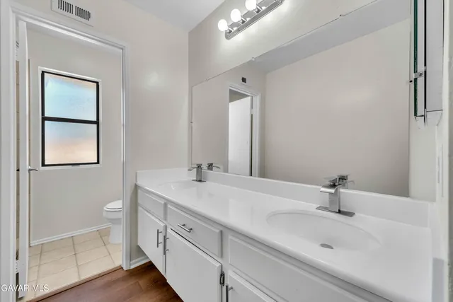 a bathroom with a sink a toilet and a mirror