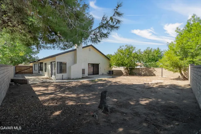 a view of a house with backyard and a tree