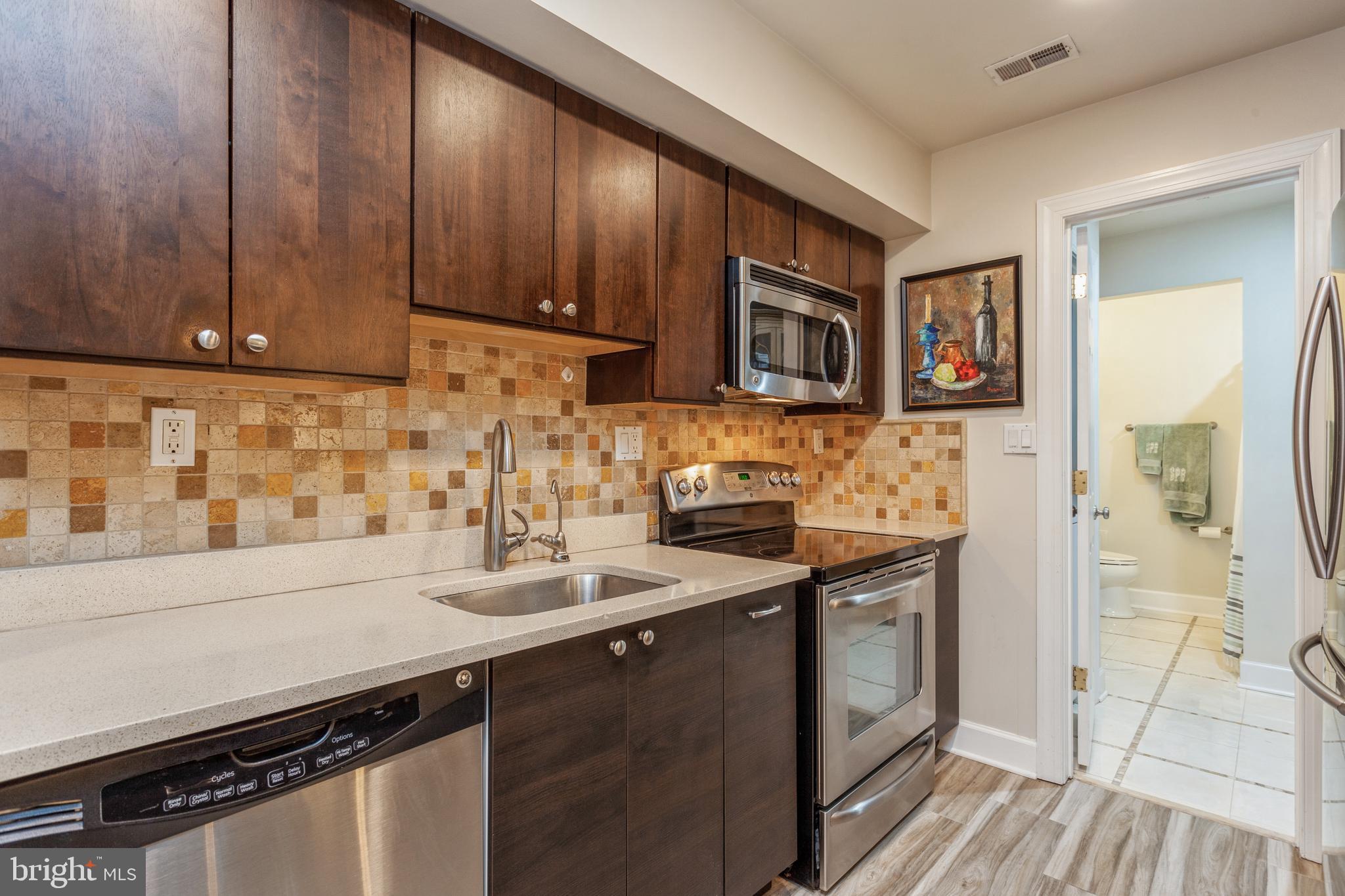 304 Q Street Northwest, Unit 1 Washington, DC 20001 - Photo 3 of 36 a kitchen with stainless steel appliances granite countertop a sink stove and cabinets
