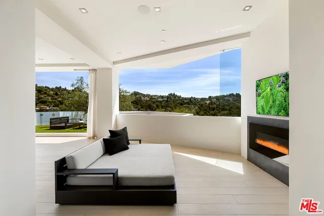 a view of swimming pool with seating area and trees in the background