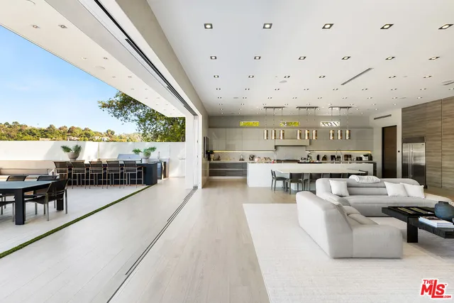 a living room with furniture a flat screen tv and a large window