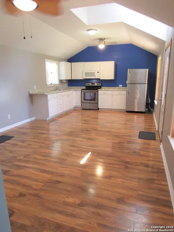 a view of kitchen with granite countertop cabinets and wooden floor